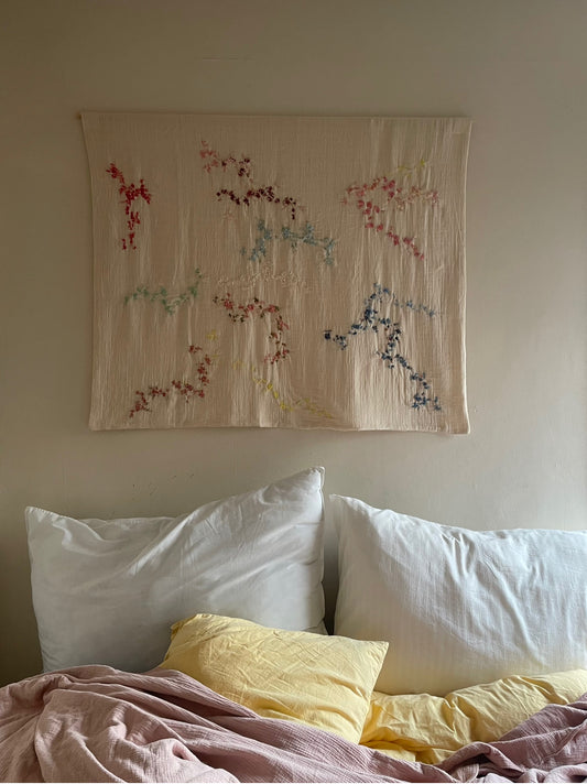 Aya -Handcrafted Wall Hanging, fully embroidered 120x100 cm, displayed on a bedroom wall.
