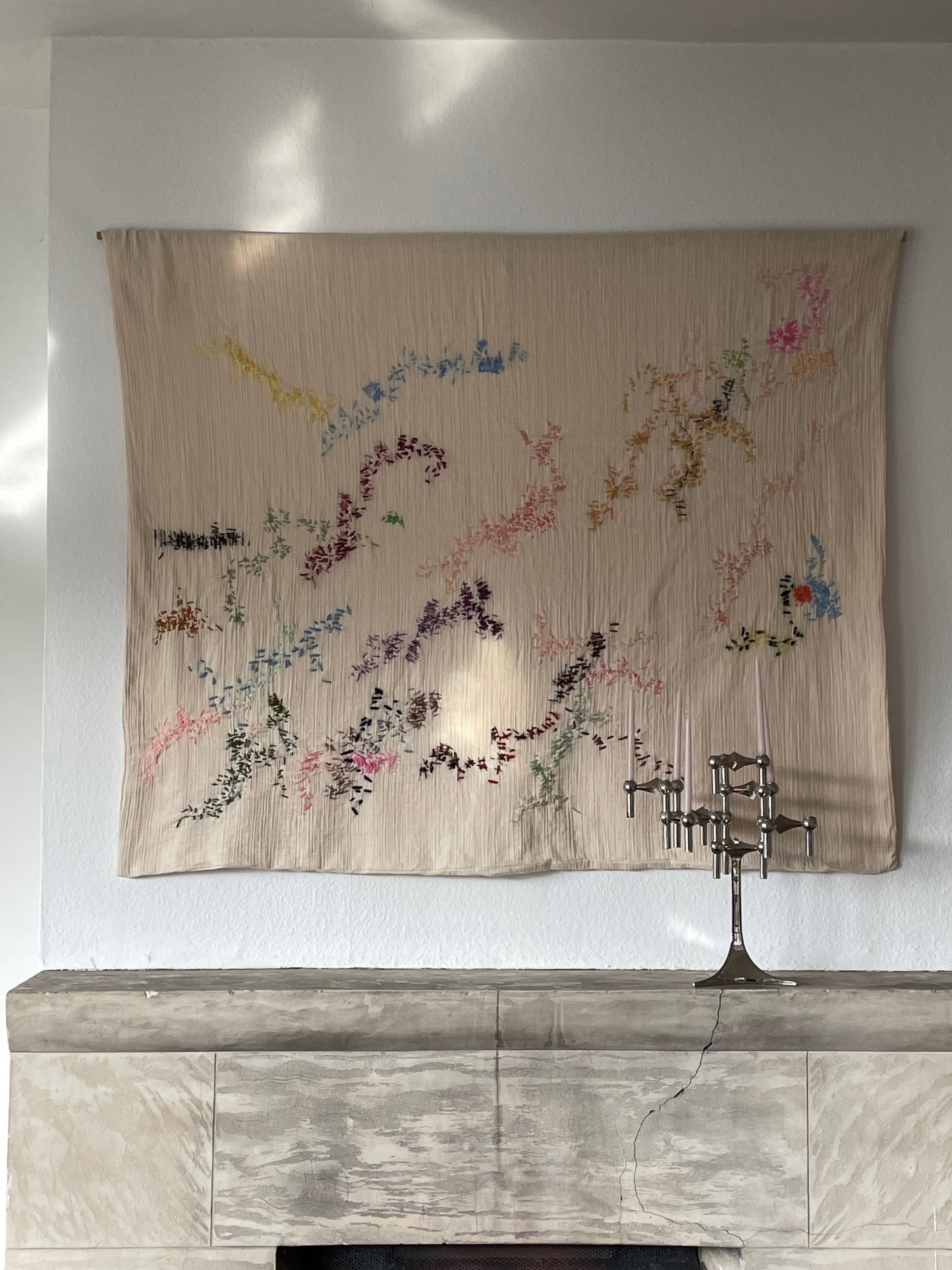 Barbara - Handcrafted Wall Hanging, fully hand embroidered 120x100 cm, displayed on a living room wall above a fireplace.