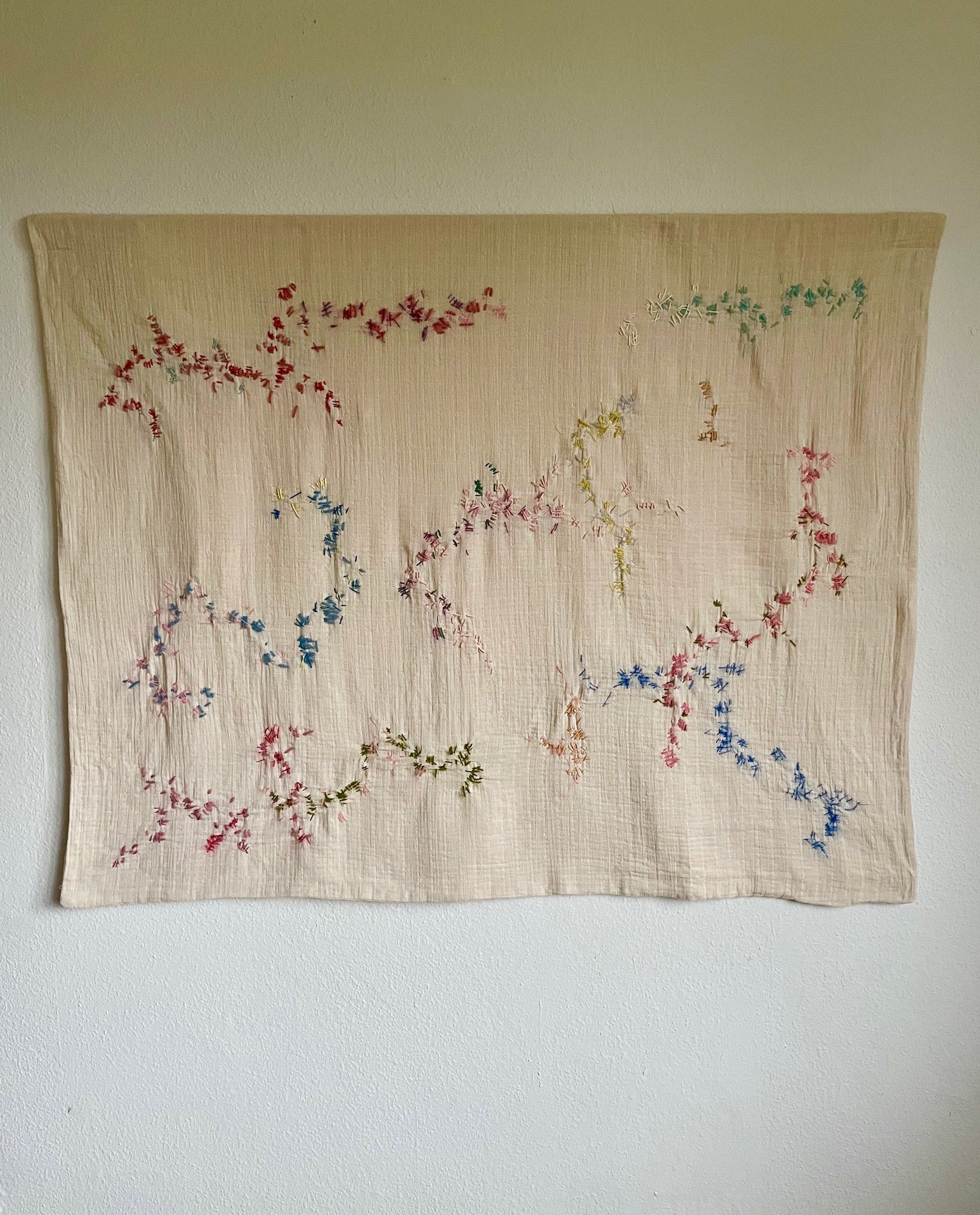 Fanny - Handcrafted wall hanging, fully hand embroidered 120x100 cm, displayed on a white wall
