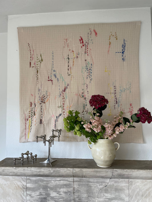 Helen - Handcrafted Wall Hanging , hand embroidered 130x130 cm, displayed on a wall above a fireplace