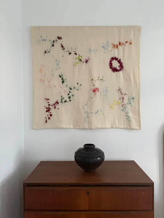 Iris - Handcrafted Wall Hanging, fully hand embroidered 90x90 cm, displayed on a bedroom wall