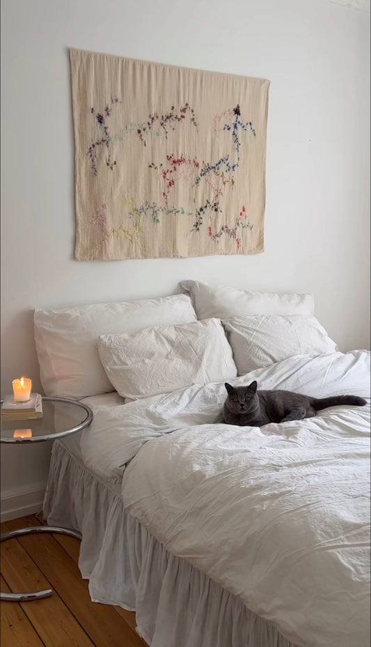 Sienna - Handcrafted Wall Hanging, fully hand embroidered 120x100 cm, displayed on a bedroom wall above a bed.